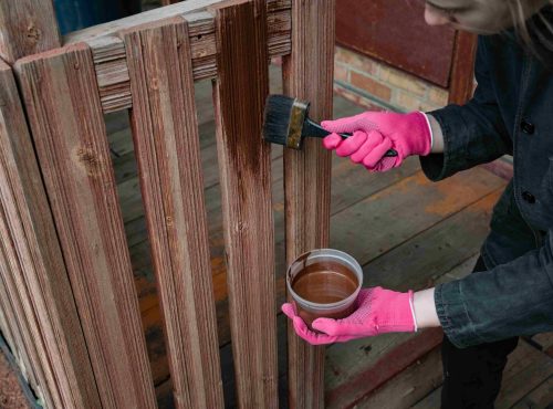 woman-staining-wooden-fence-outdoors-in-pink-glove-2026-03-26-23-19-46-utc_11zon
